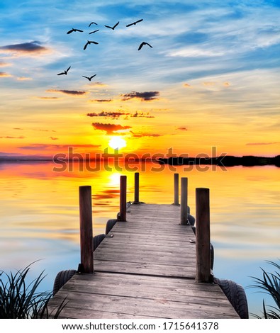 colorful sunset at the lake jetty Royalty-Free Stock Photo #1715641378