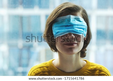 Woman in medical mask on eyes. Panic, fear, lying or disinformation during coronavirus pandemic concept. Royalty-Free Stock Photo #1715641786
