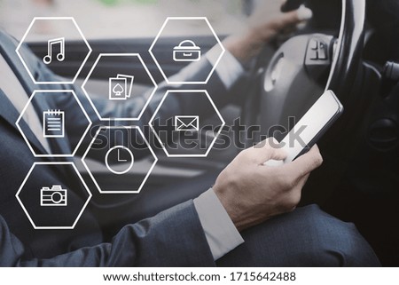 Social Media Marketing Concept. Businessman using smart phone, driving car, double exposure with VR icons, side view