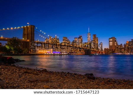 Magical evening sunset view of the Brooklyn bridge from the Brooklyn park with a lower Manhattan view on the other side of the Hudson river.