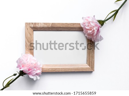 Wooden photo frame. Pink carnation. White background. Frame on a white background.