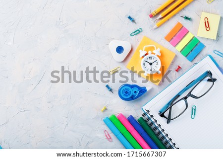 School stationery lies on a gray textural background with free space.