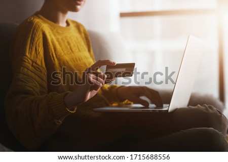 Woman holding credit banking card and typing information with laptop. Online shopping and paying in internet during coronavirus quarantine Royalty-Free Stock Photo #1715688556