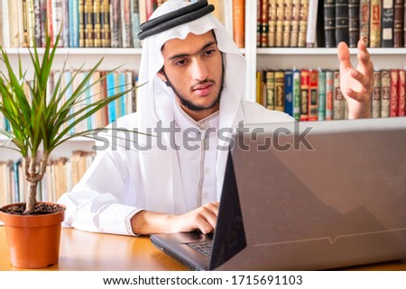 Arabic muslim man using his laptop to do seminars online