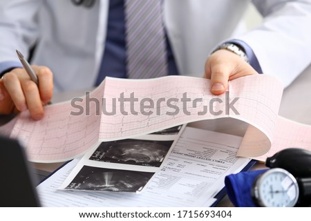 Doctor explains cardiogram data, consultation. Repeated consultation, doctor develops an optimal treatment regimen, explains how to properly control state health. Prevention, treatment heart disease. Royalty-Free Stock Photo #1715693404