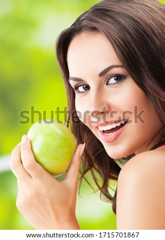Portrait picture of happy smiling woman with green apple