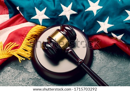 Judge's wooden gavel on background of American flag on black background Royalty-Free Stock Photo #1715703292