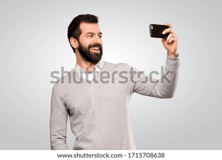 Handsome man making a selfie over isolated grey background