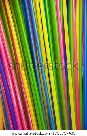 Collage of multicoloured plastic drinking straws creating a rainbow pattern