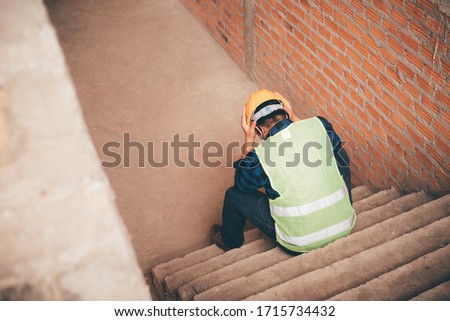 Sitting construction workers are worried about being laid off. Royalty-Free Stock Photo #1715734432