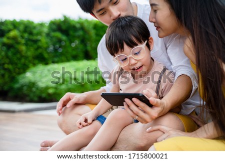happy asian family home life having fun together and using digital tablet or smart phones for playing games and watching cartoons, smart phone mobile addiction technology communication lifestyles.