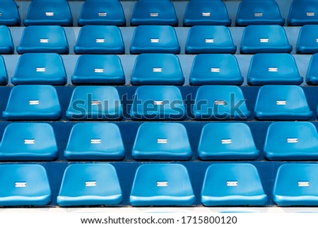 Blue stadium seats with number. Empty plastic chairs in stadium. Royalty-Free Stock Photo #1715800120
