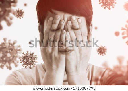 Concept of fear of coronavirus. Woman covers her face her hands on background with coronavirus. Royalty-Free Stock Photo #1715807995