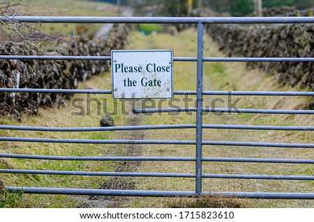 Sign asking visitors to close the gate of a field