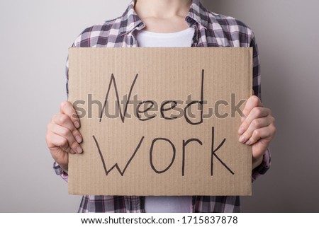 I need work concept. Cropped close up photo of unhappy female holding showing sign board with text isolated over gray background