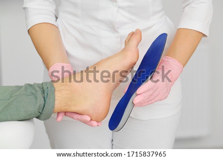 Orthopedic insoles. Fitting orthotic insoles. Flatfoot treatment. Podiatry clinic. Royalty-Free Stock Photo #1715837965
