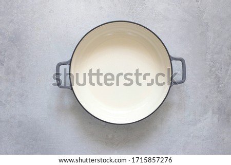 An empty cast-iron pot on a gray concrete background. The view from the top Royalty-Free Stock Photo #1715857276