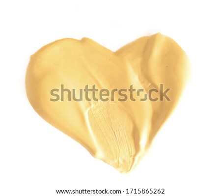 Golden shiny brush stroke paint in the shape of a heart texture on white background. Beautiful textured golden strokes, abstract background with place for text.
