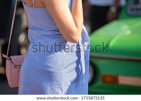 Close up of pregnant woman in summer dress outdoors.