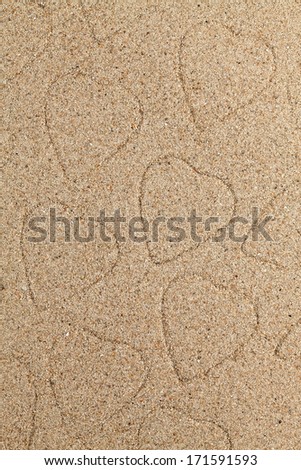 The symbol of heart is drawn on clean sand