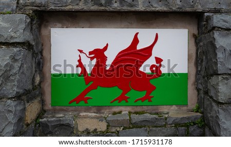 The flag of Wales in a panel inside a stone wall.