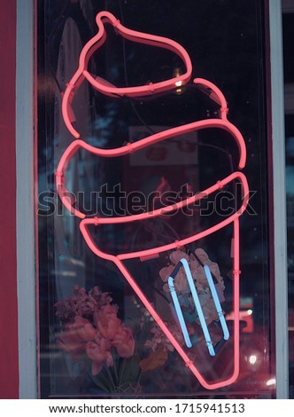 Large electric neon ice-cream sign on a storefront.