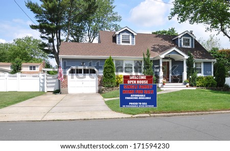 Real Estate For Sale Welcome Open House Sign Suburban Cape Cod Style Home Cement Driveway Landscaped Residential Neighborhood Street USA blue sky clouds