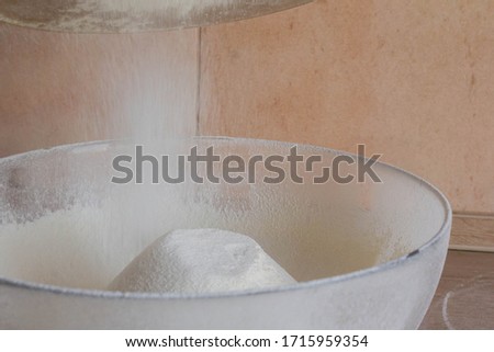 sow white flour in a clear glass bowl on a wooden table. the concept of baking