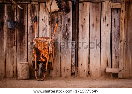 
orange wheelbarrow on a wall
