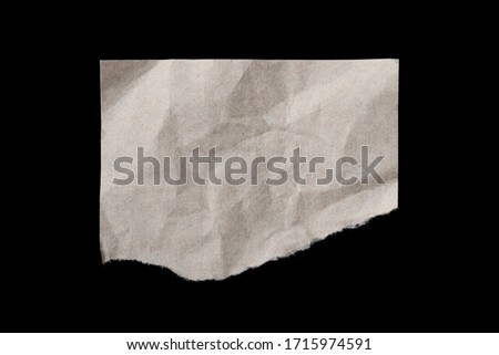 Torn crumpled beige paper sheet isolated on blackbackground