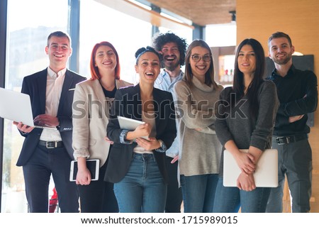 Portrait of successful creative business team looking at camera and smiling. Diverse business people standing together at startup. Royalty-Free Stock Photo #1715989015