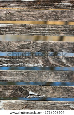 Wooden fence background, water behind aged planks