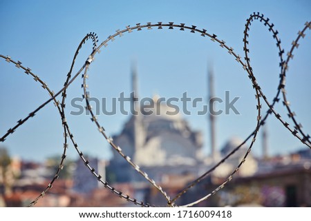 Mosque behind the barbed wire. Conceptual photo about the severe limitations of the Islamic faith