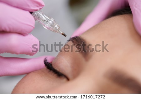 Female permanent eyeliner tattoos enhancement coloring in spa Royalty-Free Stock Photo #1716017272