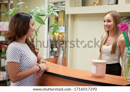 Smiling receptionist talking to the female customer day spa