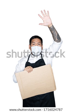 Bearded asian men waiter, chef dressed in black apron with medical mask and holding cardboard open hand doing stop sign in white background.The concept of protest. Place for text.  Clipping path.
