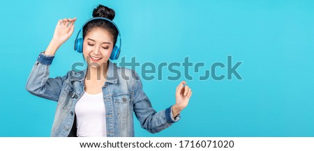 Young happy attractive asian woman using headphone enjoy listen to song in concept of next normal life, pastime or hobby online. Quarantine activity asian lifestyle listening to music on radio online. Royalty-Free Stock Photo #1716071020