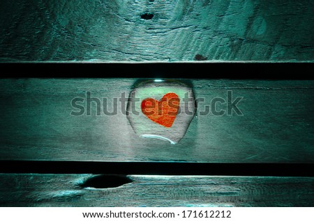 Red heart in water drop on wood pattern background