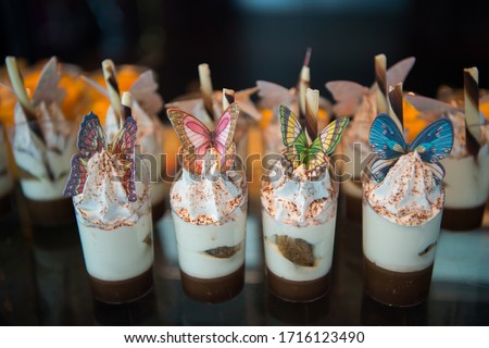 Dessert in a clear glass with butterflies on top