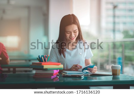 A woman teenager reading and writing book, teenager happy education in university or high school.