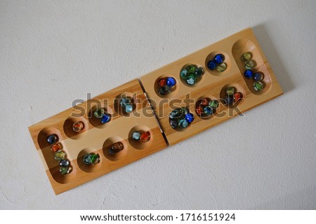 Top view of a dakon or congklak game which is a mancala marble game of Malay in white background. Origin played in Malaysia, Philippines, Singapore, Indonesia, Brunei and Thailand.
