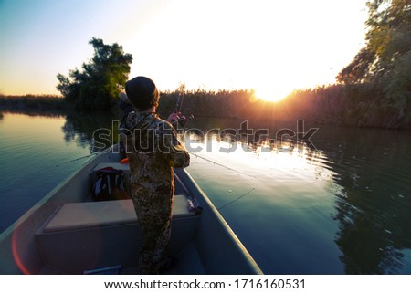 Anglers fishing from the boat on the calm river in Astrakhan Region in Russia. Astrakhan is a famous fishing destination