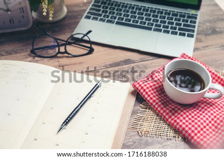 Calendar Laptop and for Planner to plan reminder daily appointment timetable, appointment, organization ,and meeting agenda of job on wooden desk, work from home. 