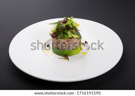 Freshly cooked tartare served with lime on white plate on black background