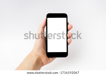 Mockup image of hand holding black mobile phone with blank white screen.