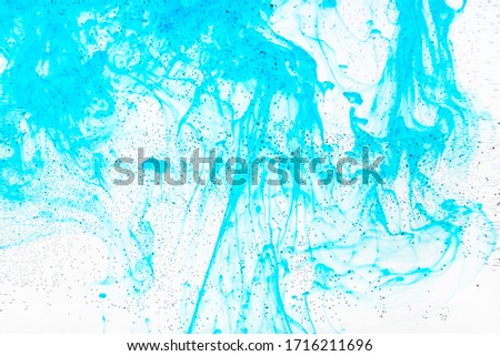 air bubbles on glass surface of flat bottle and aquamarine ink flow in water on background