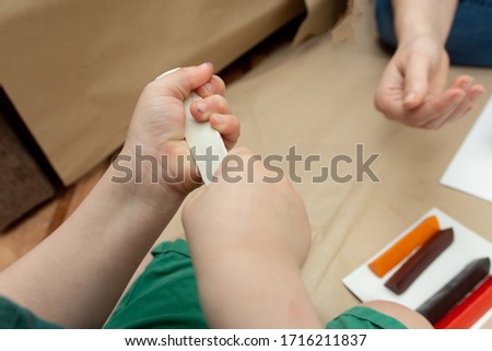 a white piece of plasticine in children's hands. close-up. children's creativity.
