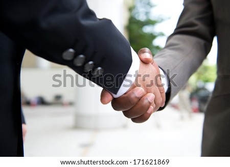 African businessman's hand shaking white businessman's hand  making a business deal. Royalty-Free Stock Photo #171621869