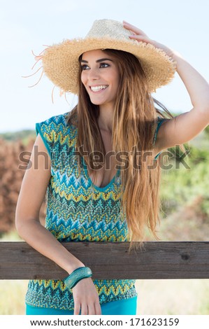 Portrait Of A Happy Girl Wearing Straw Hat Looking Away