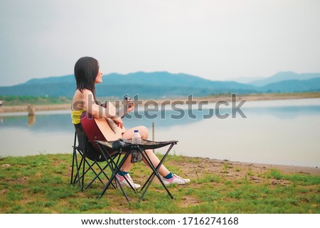 woman traveler have camping and picnic alone near the lake on vacation. 